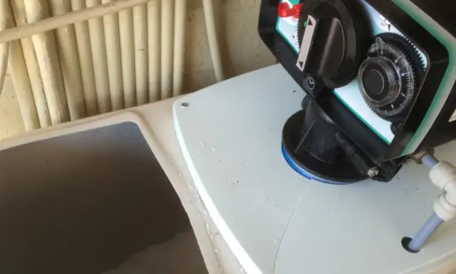 Le panneau de contrôle d'un adoucisseur d'eau, prêt pour la regeneration. Des tuyaux sont visibles en arrière-plan.