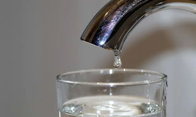 Une goutte d'eau potable de Rouen tombe dans un verre.