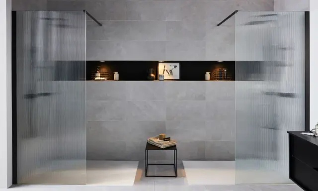 Une salle de bain moderne avec une douche et une baignoire, séparées par des parois en verre texturé.
