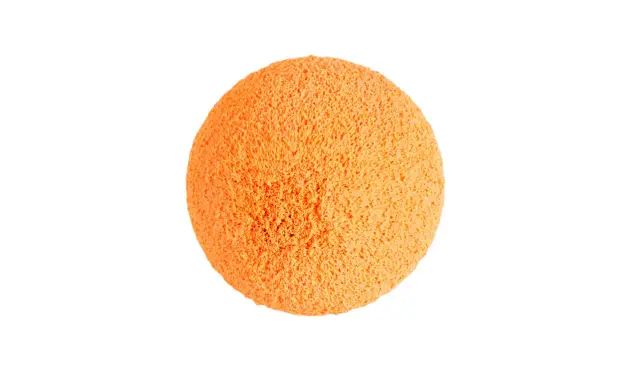 Une balle de nettoyage orange, texturée et spongieuse, prête à faire briller votre maison.