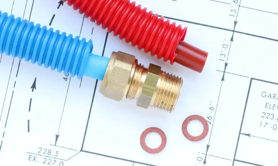 Tuyaux din40 bleus et rouges, raccord laiton et rondelles sur un plan technique.