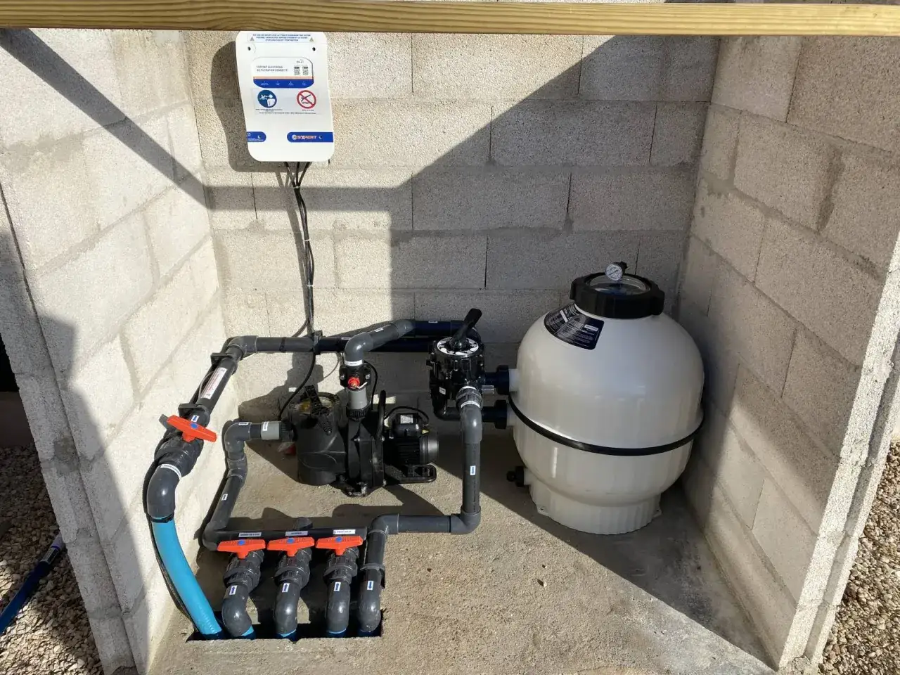 Système de filtration de piscine avec pompe et filtre à sable. Une armoire électrique est fixée au mur. Cette local technique piscine 2m2 est prête à l'emploi.