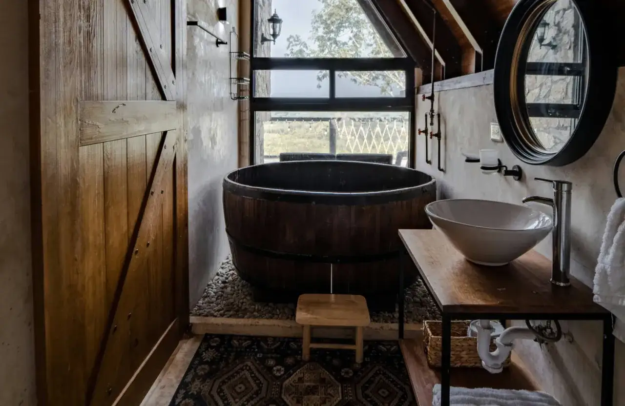 Bain en bois rustique, lavabo moderne et porte coulissante en bois. Une inspiration salle de bain naturelle et chaleureuse.