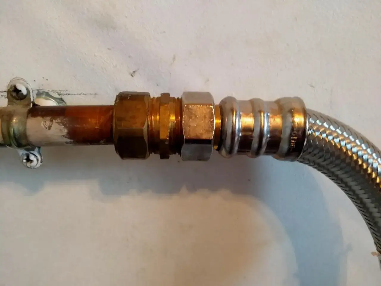 Raccordement de plomberie avec une rallonge 1/2 male femelle, connectant un tuyau en cuivre à une tresse métallique.